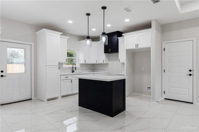 kitchen featuring sink, a kitchen island, hanging light fixtures, and plenty of natural light