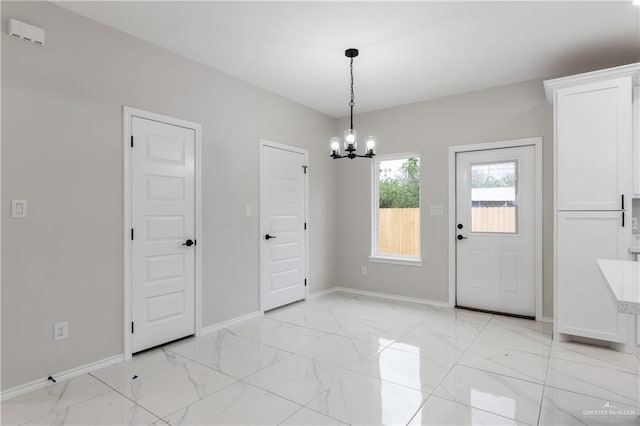 unfurnished dining area with a chandelier