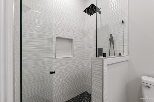 bathroom featuring toilet and tiled shower