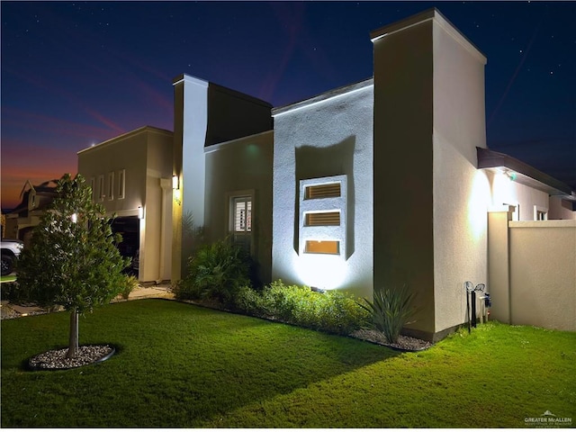 property exterior at dusk with a lawn