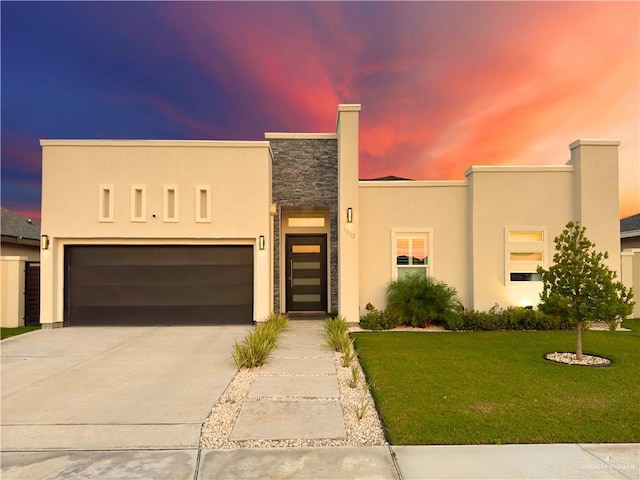 view of front facade with a yard and a garage