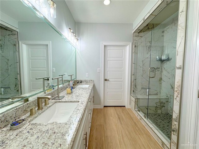 bathroom with vanity, a shower with shower door, and hardwood / wood-style flooring