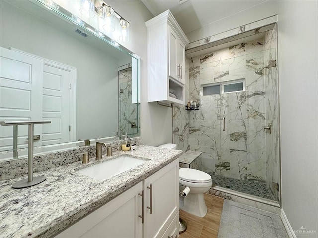 bathroom with vanity, wood-type flooring, a shower with shower door, and toilet