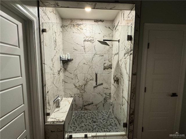 bathroom featuring a shower with shower door