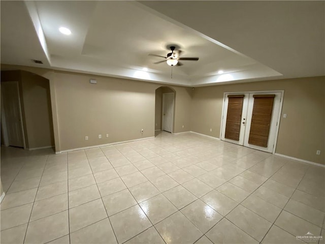 8500 S Norma St, Pharr, TX 78577 - spare room with baseboards, a raised ceiling, ceiling fan, arched walkways, and light tile patterned flooring