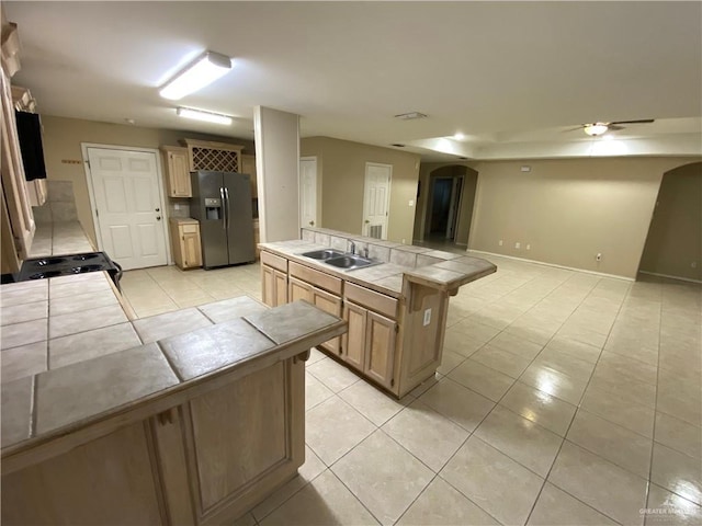 8500 S Norma St, Pharr, TX 78577 - kitchen with tile countertops, light tile patterned flooring, a sink, stainless steel fridge with ice dispenser, and arched walkways