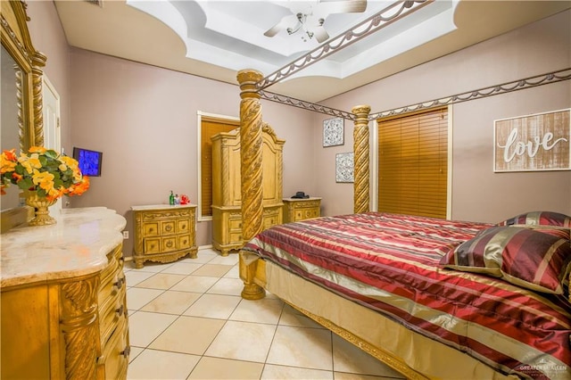 tiled bedroom with ceiling fan and a raised ceiling