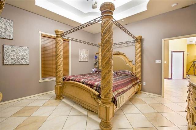 bedroom featuring light tile patterned floors, a raised ceiling, and ceiling fan