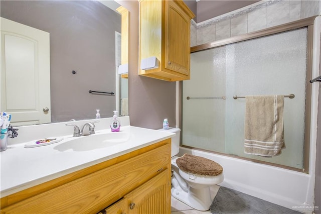 full bathroom with tile patterned floors, vanity, toilet, and bath / shower combo with glass door