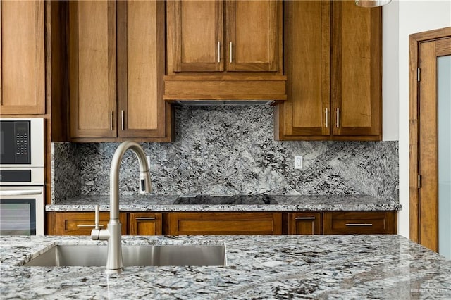 820 N Brushfield Ave, Edinburg, TX 78541 - kitchen featuring a sink, black appliances, tasteful backsplash, and brown cabinetry