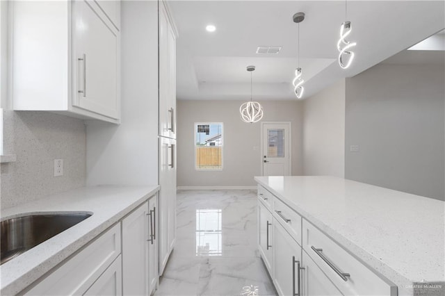 2208 Zinnia St, Weslaco, TX 78599 - kitchen featuring light marble finish flooring, a tray ceiling, white cabinets, pendant lighting, and recessed lighting