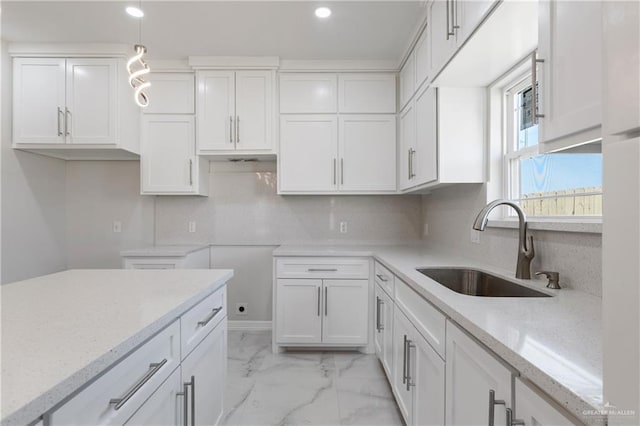 2208 Zinnia St, Weslaco, TX 78599 - kitchen featuring a sink, light stone counters, white cabinets, light marble finish floors, and recessed lighting