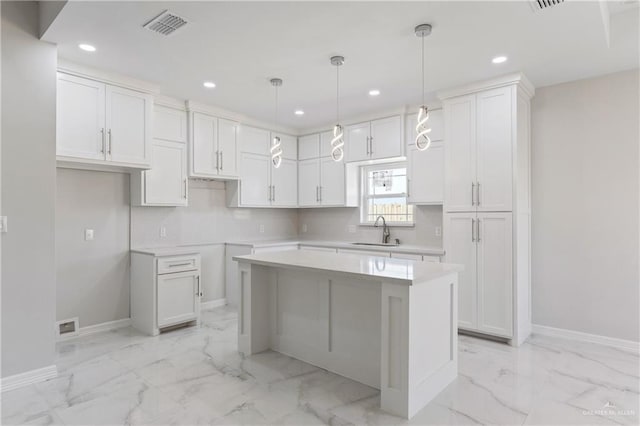 2208 Zinnia St, Weslaco, TX 78599 - kitchen featuring a sink, recessed lighting, baseboards, light marble finish floors, and a kitchen island
