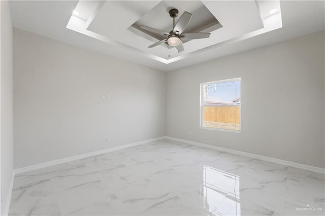 2208 Zinnia St, Weslaco, TX 78599 - empty room with baseboards, a tray ceiling, marble look tiles, and ceiling fan