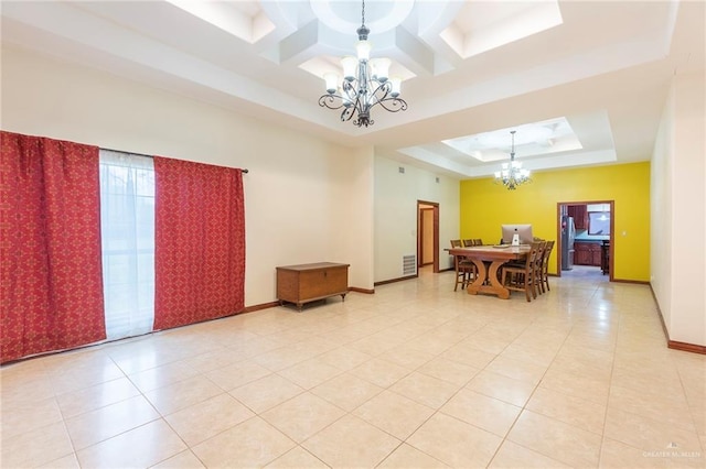 interior space featuring light tile patterned floors, coffered ceiling, a tray ceiling, and a notable chandelier