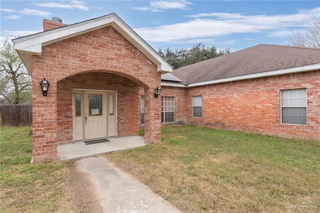 property entrance with a lawn