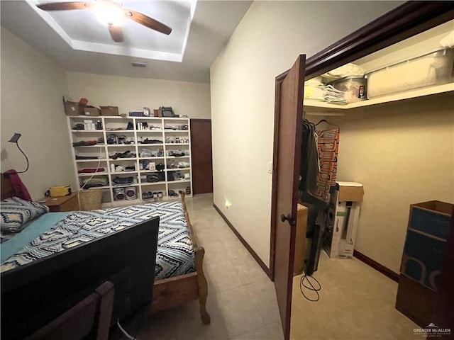 bedroom featuring ceiling fan and a raised ceiling