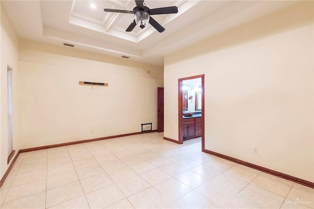 tiled empty room featuring ceiling fan, a tray ceiling, and coffered ceiling