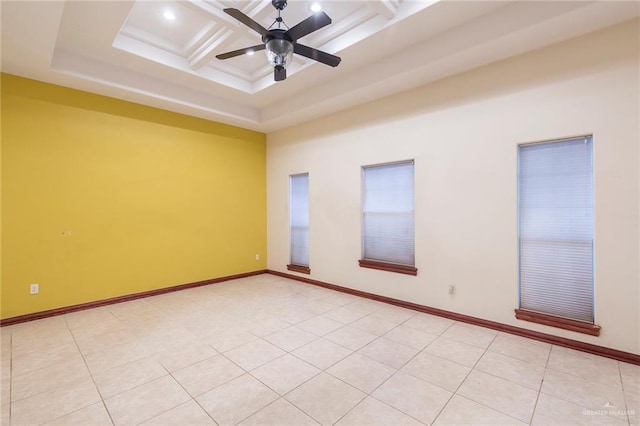 tiled spare room with ceiling fan, coffered ceiling, and beamed ceiling