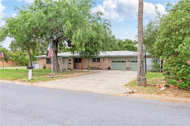 1601 Walnut Ave, Mcallen, TX 78501 - ranch-style house with a garage, concrete driveway, brick siding, and metal roof