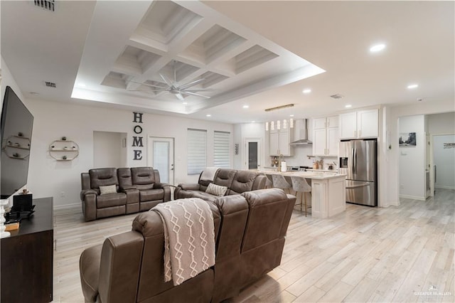 living room featuring beam ceiling, ceiling fan, light hardwood / wood-style floors, and coffered ceiling