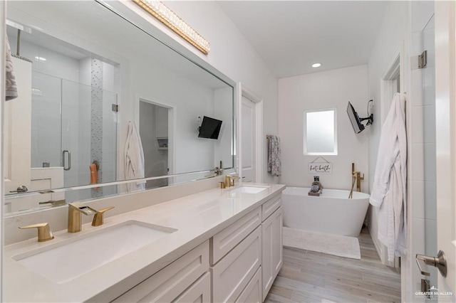 bathroom featuring hardwood / wood-style floors, vanity, and separate shower and tub