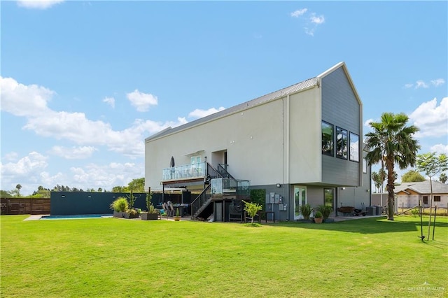 rear view of house with central air condition unit and a yard