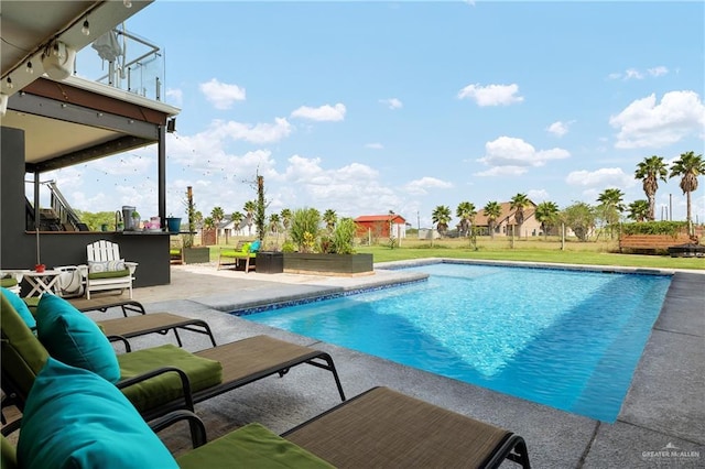 view of pool with an outdoor living space, a lawn, and a patio area