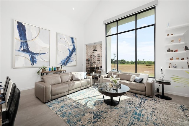 living room with high vaulted ceiling and wood-type flooring