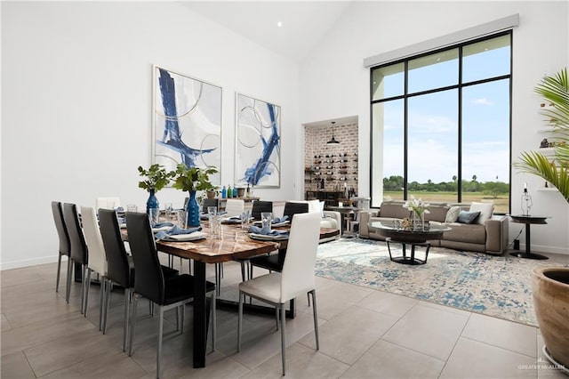 tiled dining area featuring high vaulted ceiling