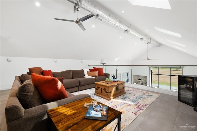 living room with a skylight, high vaulted ceiling, ceiling fan, and beam ceiling