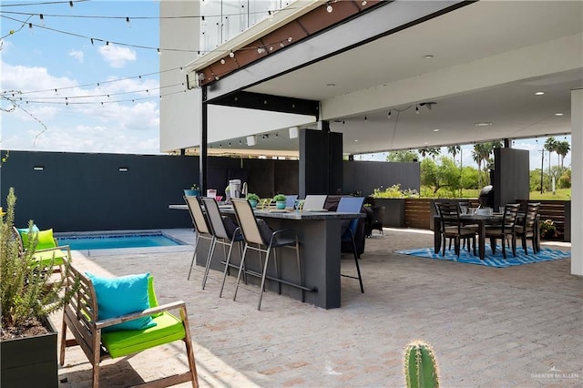 view of patio / terrace with a fenced in pool and a bar