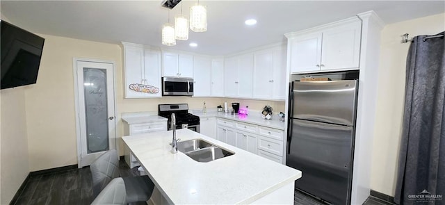 kitchen with stainless steel appliances, white cabinetry, and a sink