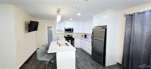 kitchen featuring stainless steel appliances, dark wood-type flooring, a sink, visible vents, and light countertops