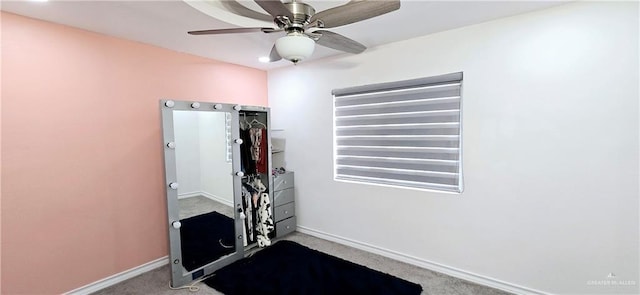 exercise area featuring carpet flooring, a ceiling fan, and baseboards