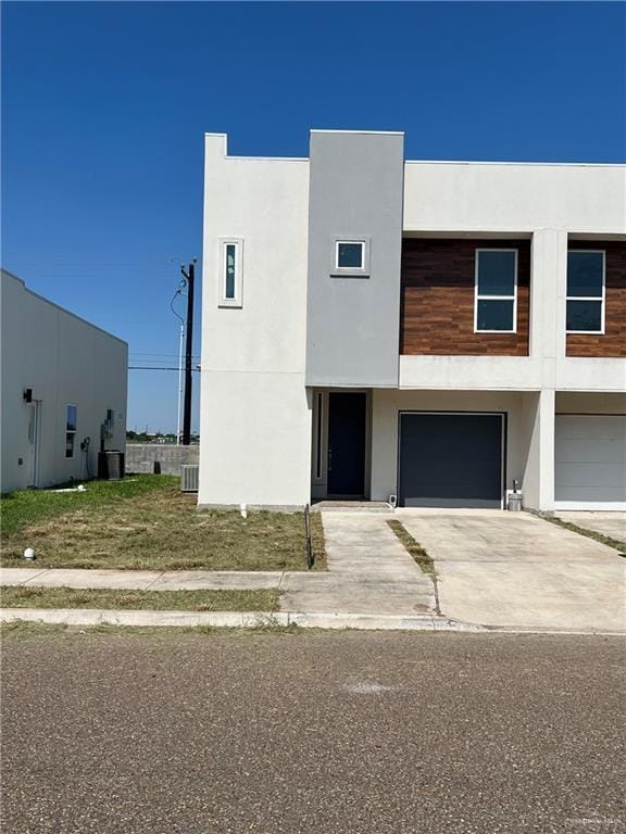 view of front of home with cooling unit and a garage