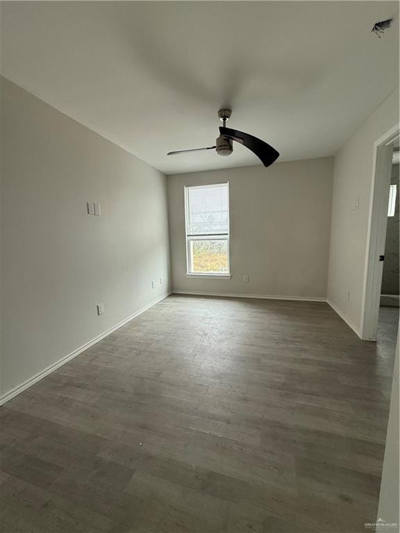 empty room with ceiling fan and dark wood-type flooring