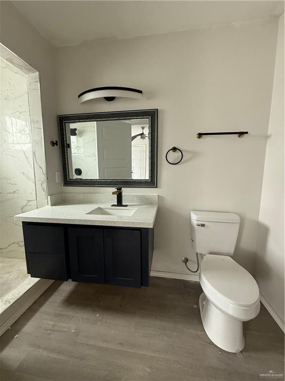 bathroom featuring hardwood / wood-style flooring, vanity, toilet, and a shower