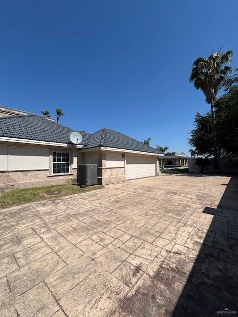 2417 E 28th St, Mission, TX 78574 - back of property with concrete driveway, a garage, and a tile roof