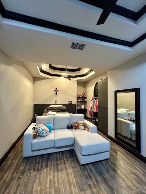 2417 E 28th St, Mission, TX 78574 - bedroom featuring wood finished floors, a raised ceiling, and a ceiling fan