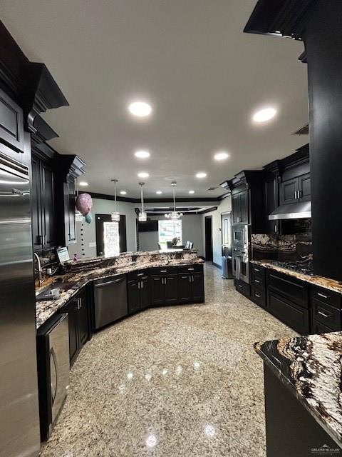 2417 E 28th St, Mission, TX 78574 - kitchen featuring stainless steel appliances, dark cabinets, under cabinet range hood, stone counters, and recessed lighting