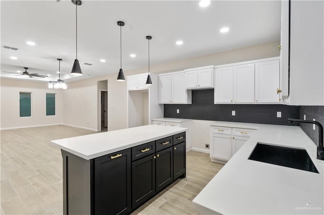 kitchen featuring white cabinets, pendant lighting, a kitchen island, and ceiling fan