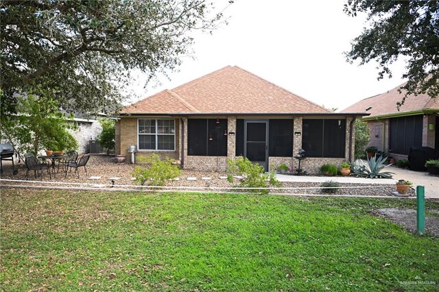 view of front of property with a sunroom and a front lawn