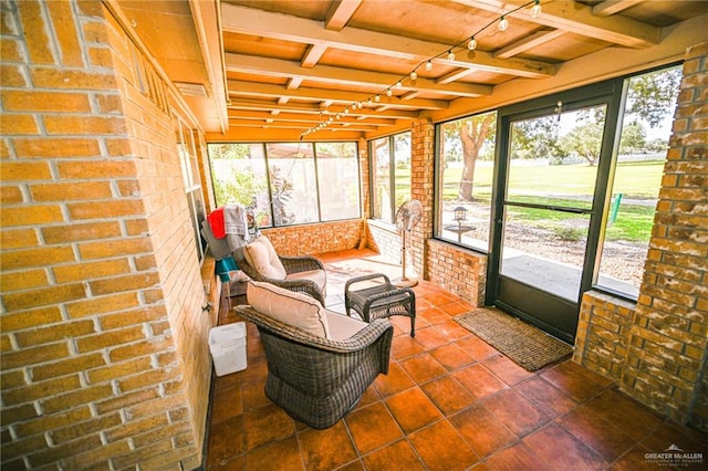 sunroom featuring beamed ceiling and plenty of natural light