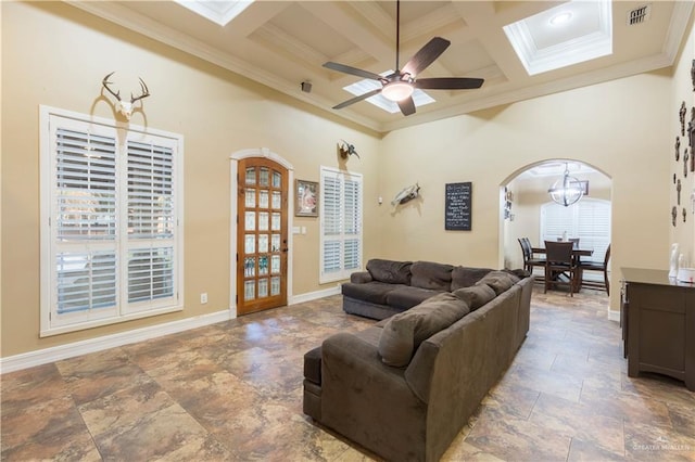 living room featuring ceiling fan, a towering ceiling, beam ceiling, coffered ceiling, and ornamental molding