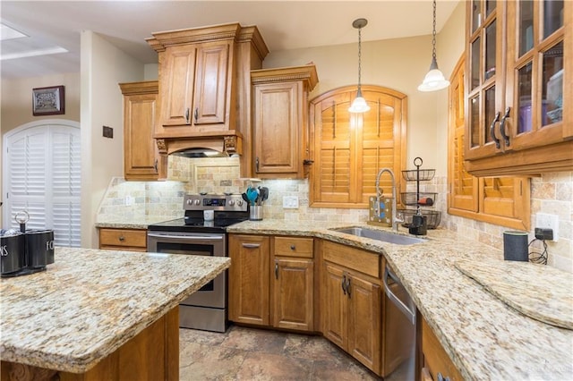 kitchen featuring sink, appliances with stainless steel finishes, backsplash, hanging light fixtures, and light stone countertops