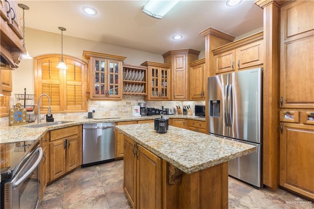 kitchen featuring sink, stainless steel appliances, a center island, tasteful backsplash, and decorative light fixtures