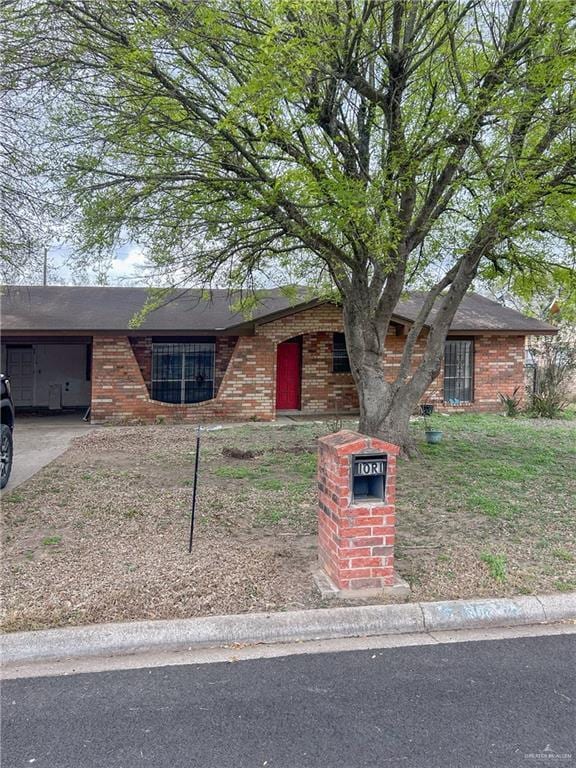 view of front facade featuring concrete driveway, brick siding, and an attached garage