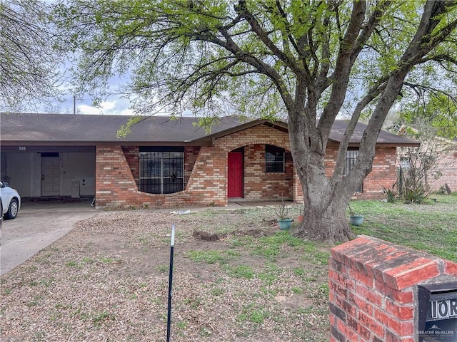 ranch-style home featuring a carport, brick siding, and driveway