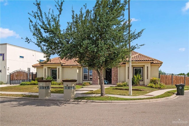 1802 E Thompson Rd, Mission, TX 78573 - mediterranean / spanish home with a tile roof, stucco siding, and a gate